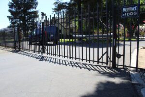 A large metal gate with a black car in background